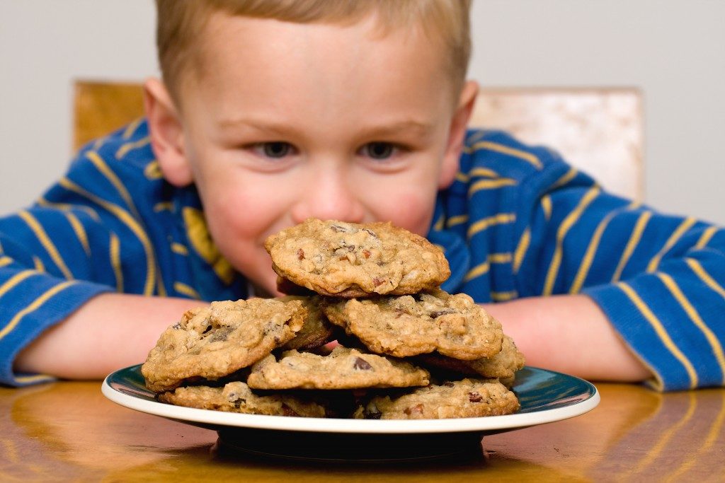 Kid looking at cookies on a plate