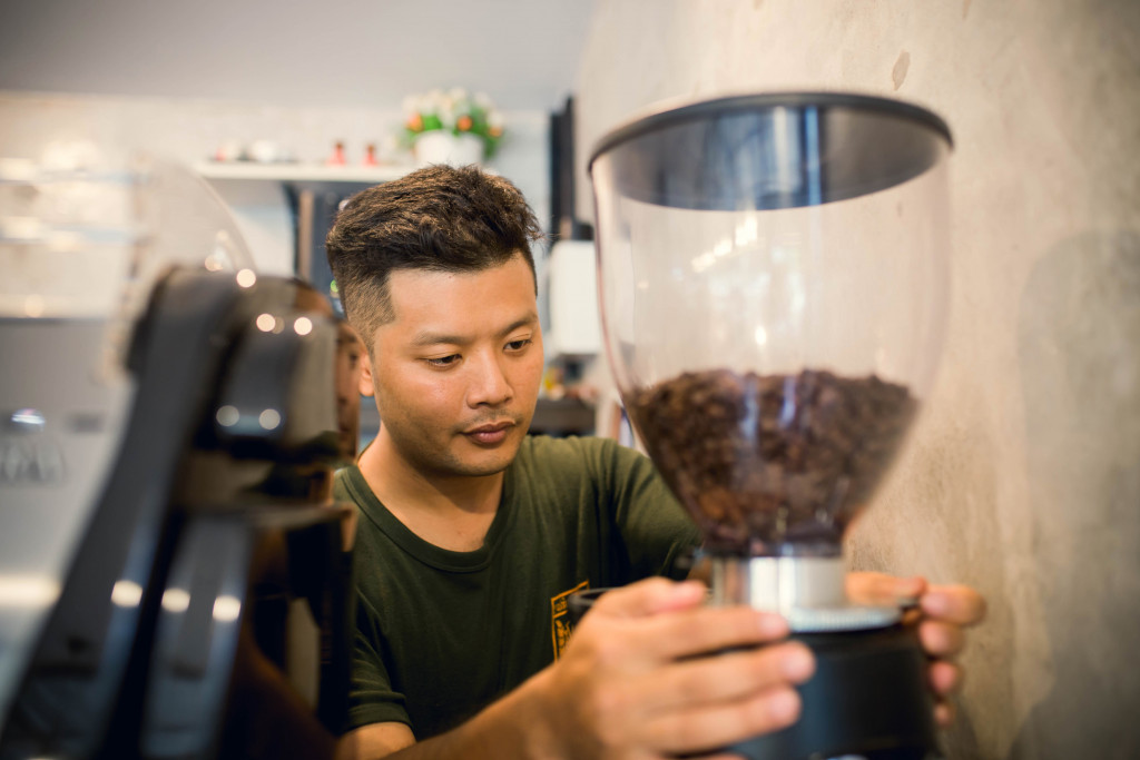 man using his coffee maker to grind beans
