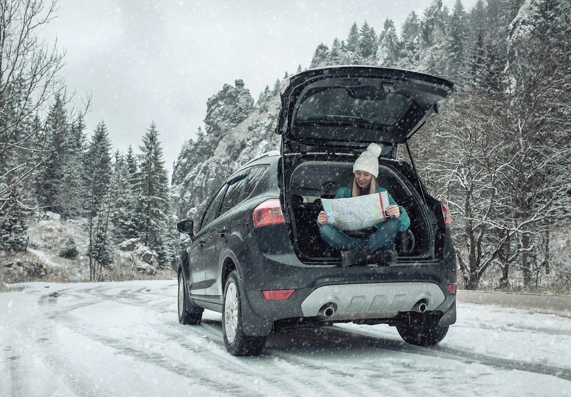 woman sitting at the back of her car during winter