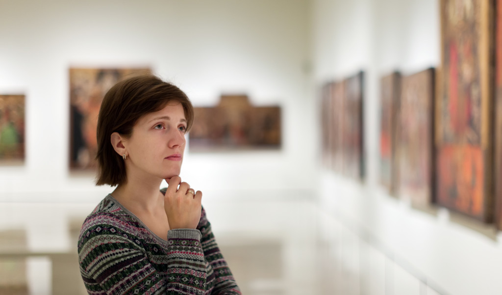woman observing artwork in museum